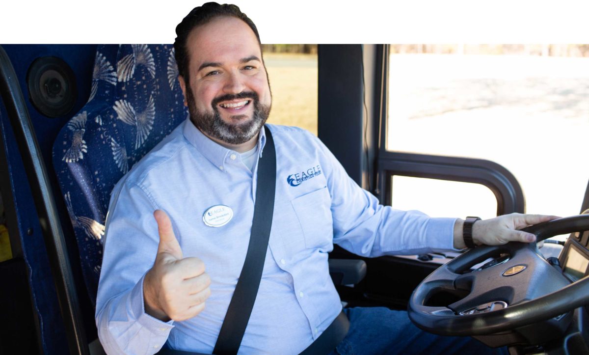 A driver smiles and gives a thumbs up