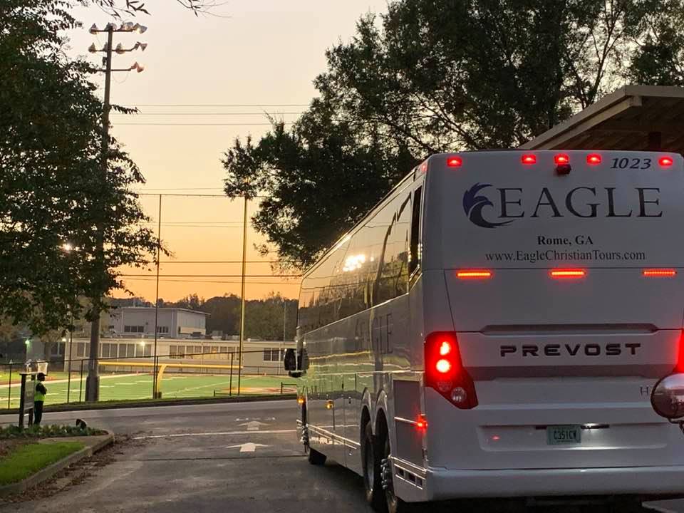 An Eagle Christian Tours bus in front of a baseball field